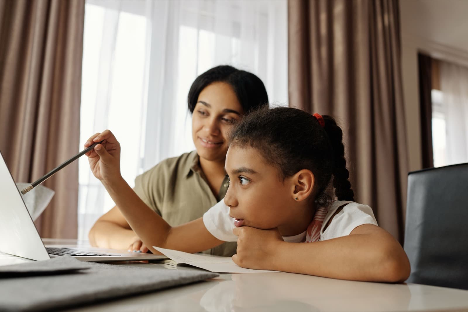 A parent and her daughter looking at a laptop together